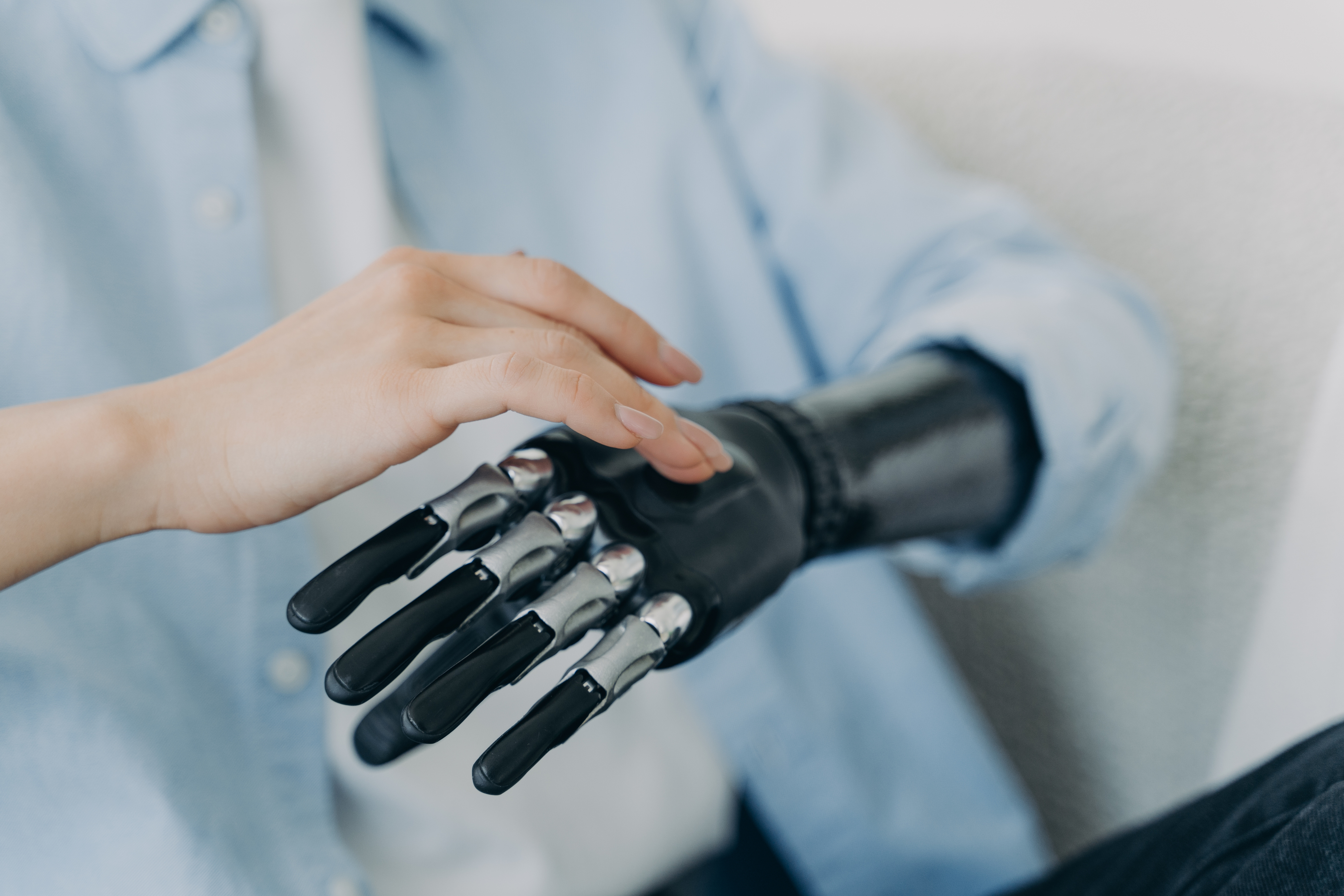 Hands of  girl setting up her bionic arm and pressing buttons. Robotic bionic prosthesis.